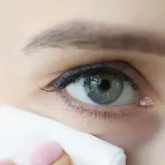 Kropla łzy spływa po oku, a chusteczka delikatnie dotyka kącika, gdzie znajduje się kanalik łzowy.