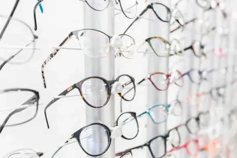 Różnorodne okulary na wystawie optyka. Zastanawiasz się, ile kosztują okulary u optyka? Znajdziesz tu modele w różnych cenach.