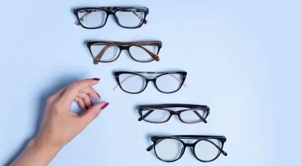 Dłoń wybiera okulary. Czy to będzie ta para, na którą czekałam, by zrealizować recepta na okulary NFZ?