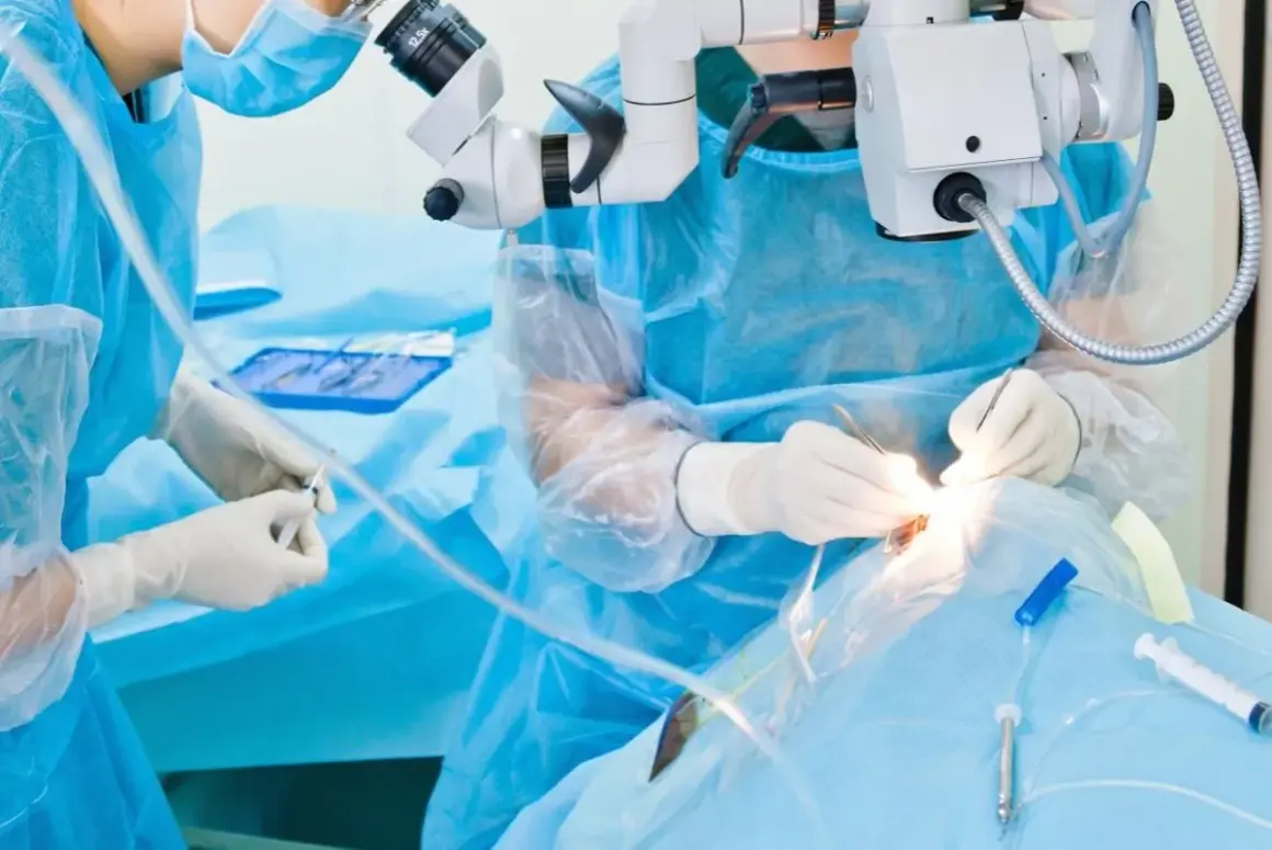 Chirurg wykonuje operację oka pod mikroskopem, używając precyzyjnych narzędzi.