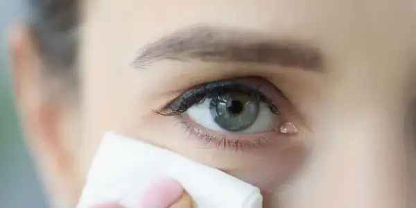 Kropla łzy spływa po oku, a chusteczka delikatnie dotyka kącika, gdzie znajduje się kanalik łzowy.