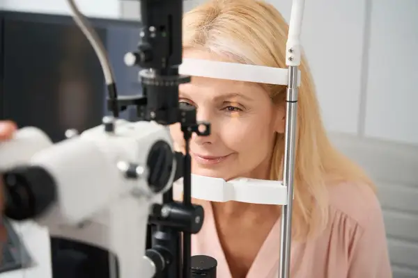 Kobieta poddawana badaniu pachymetrii oka. Urządzenie mierzy grubość rogówki, kluczowe dla diagnostyki jaskry.